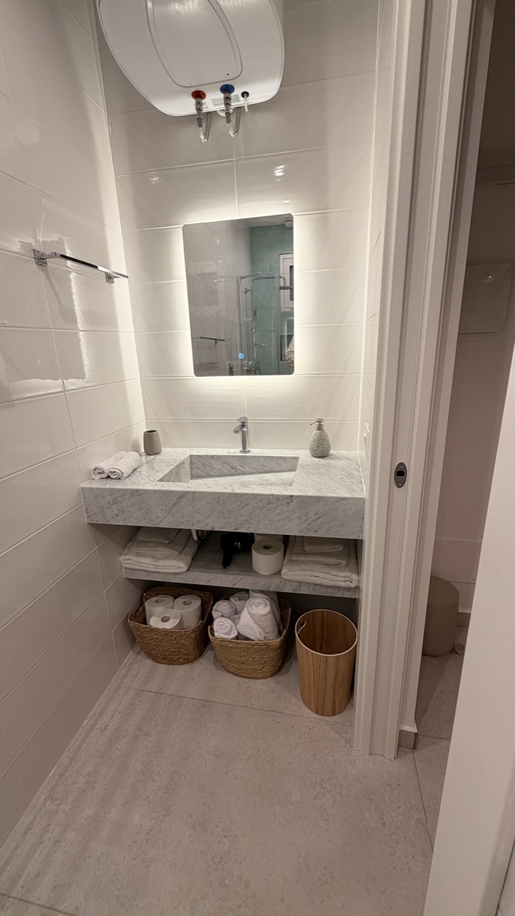 Bagno dello Studio Primo con lavabo in marmo e specchio retroilluminato